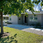 A front view of the paver walkway which leads to the front door. You'll also find a large shade tree surrounded by zoysia grass.