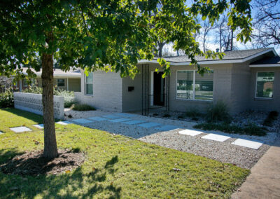 A front view of the paver walkway which leads to the front door. You'll also find a large shade tree surrounded by zoysia grass.