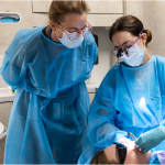 Instructor observing Dental Student working on a patient.