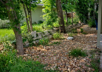 A river rock pathway leads to another bed of pollinators.