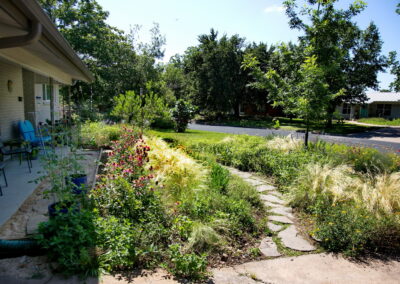 A winding road pathway cuts through the meadow garden and leads to the front porch. You'll find various colors of pollinator plants surrounding the path.