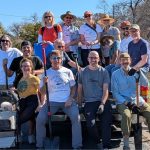 Team of WPNA Members sitting on the back of a truck posing with shovels after a tree planting on Blanton Dr