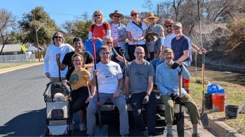 Team of WPNA Members sitting on the back of a truck posing with shovels after a tree planting on Blanton Dr